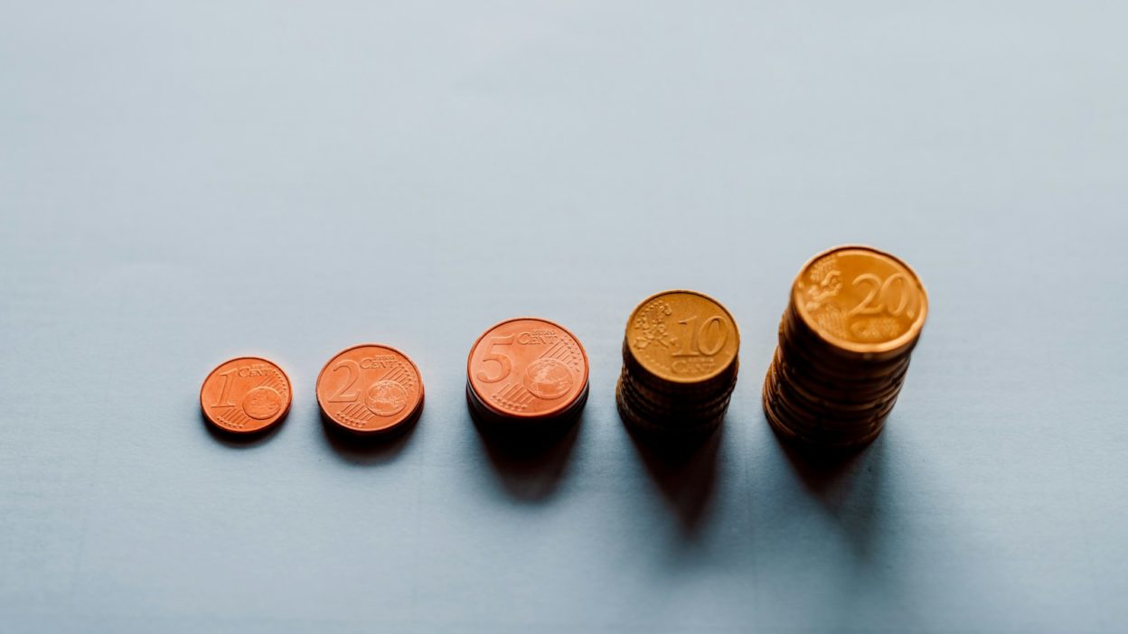 eight round gold coins on white surface